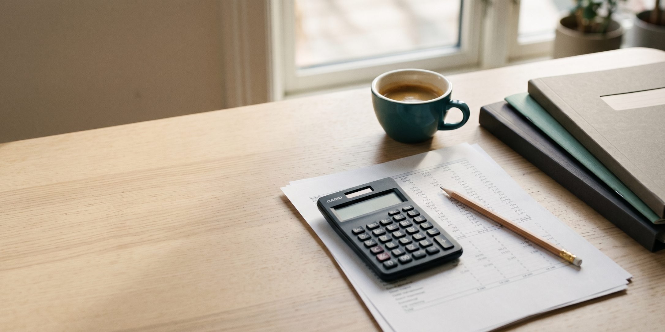 Secretária com folha de cálculo, calculadora e café — planeamento de orçamento de marketing