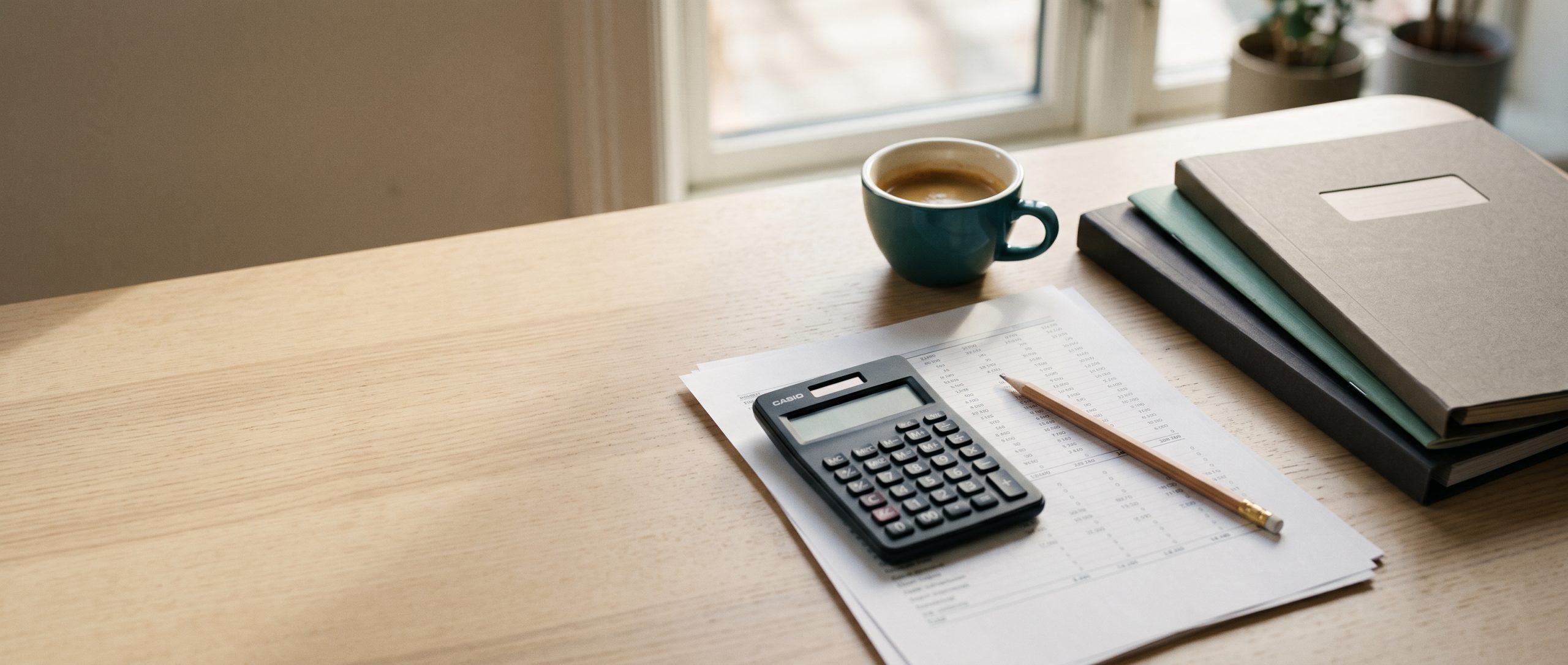 Secretária com folha de cálculo, calculadora e café — planeamento de orçamento de marketing